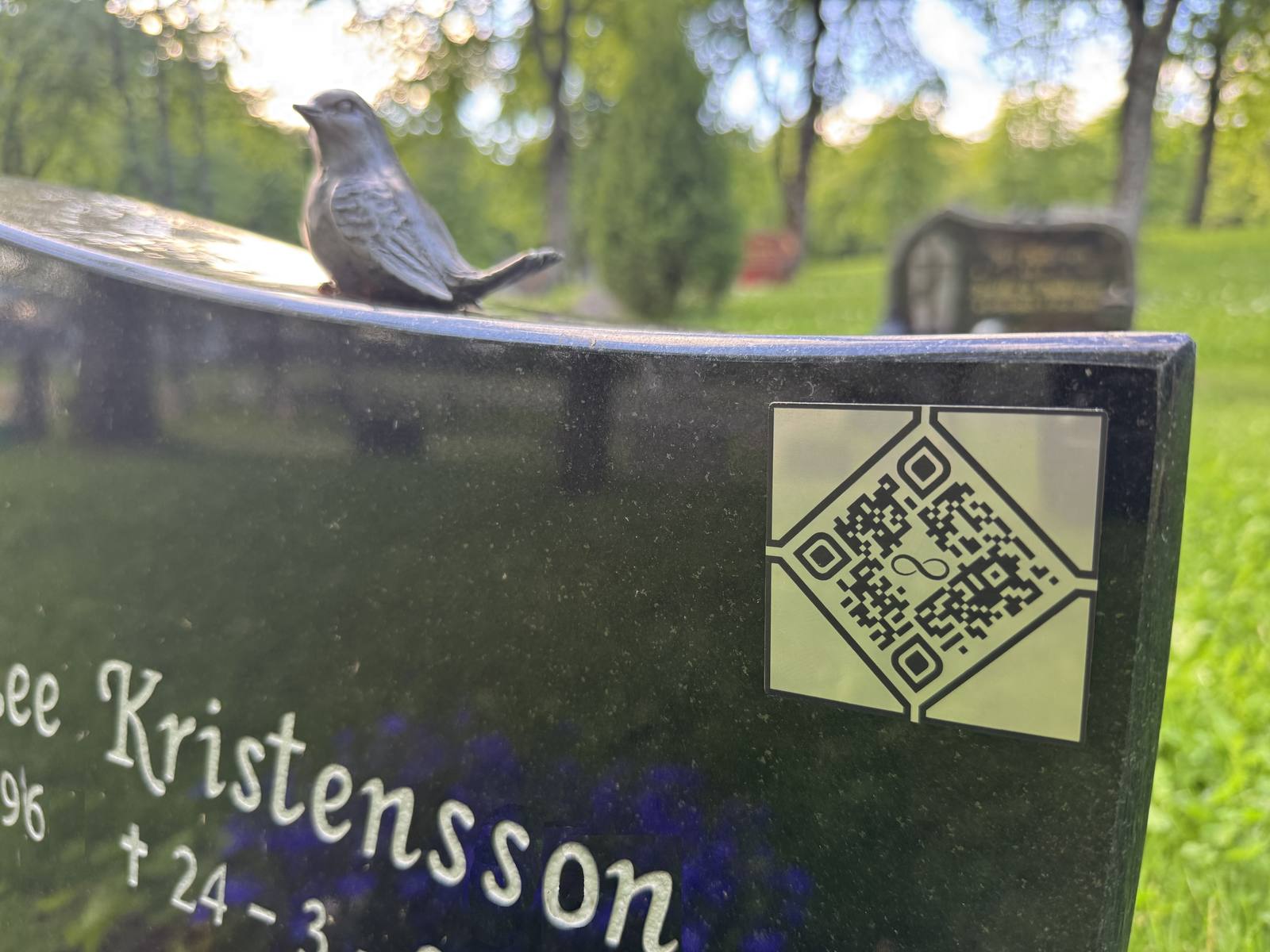Minnemerket på en svart gravstein med bronsefugl